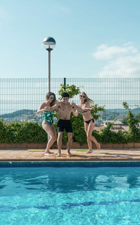 Friends playing with water pistols in the pool