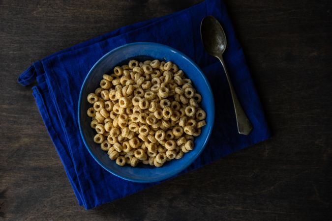 Top view of bowl of cereal in blue bowl on wooden table