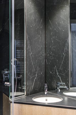 Marble sink and water tap in contemporary washroom
