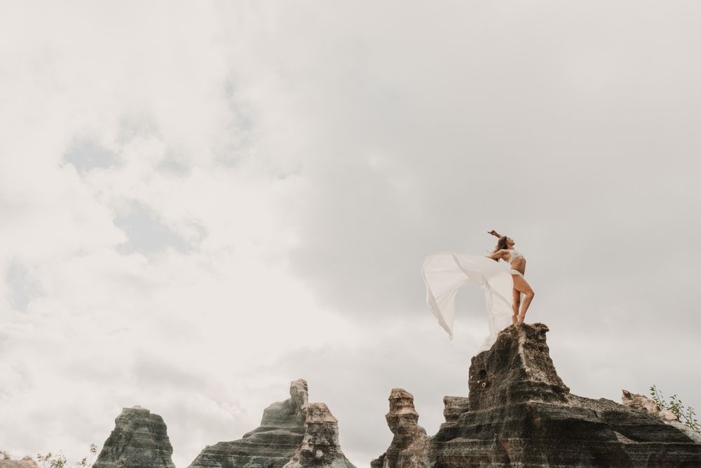 Anonymous female exercising on top of rock