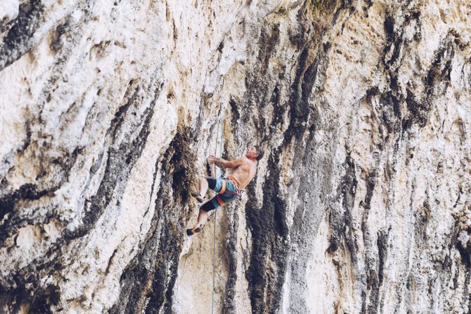Anonymous man climbing rock