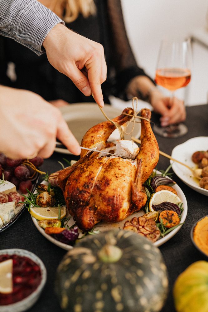 Cropped image of man cutting a turkey on dinner table
