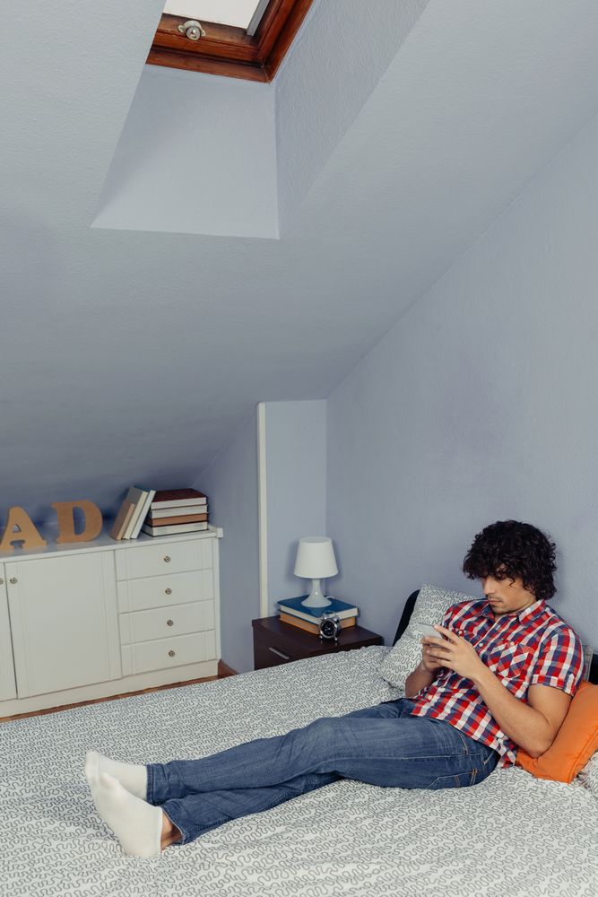 Man relaxing in bed looking at smartphone