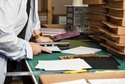 Female hands use hole punch to create perforations in removable paper blocks