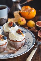 Delicious cupcakes with fruit on top plated on ceramic dish