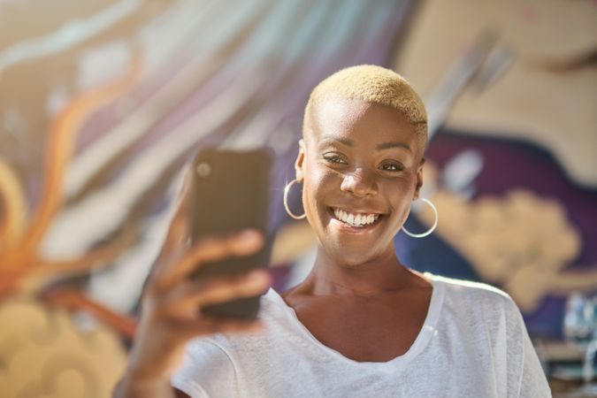 Cheerful Black woman taking selfie