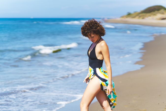 Female tourist with beach wrap on sunny seacoast