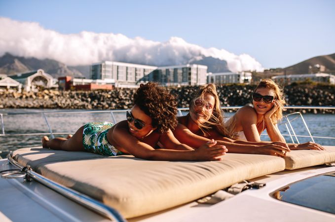 Female friends relaxing on private boat on sunny day