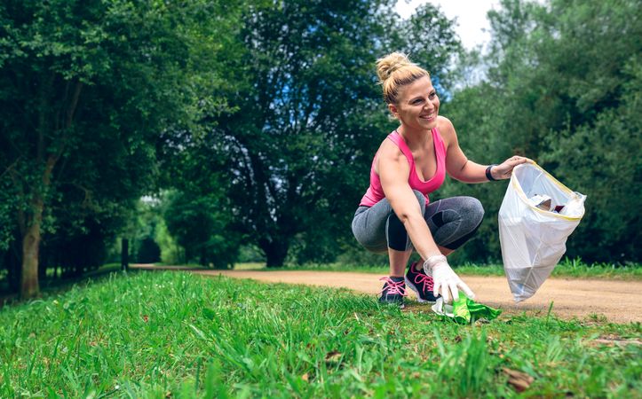 Woman picking up trash doing plogging