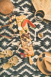 Summer picnic on pueblo pattern blanket, with board of pate, meats, and fruit