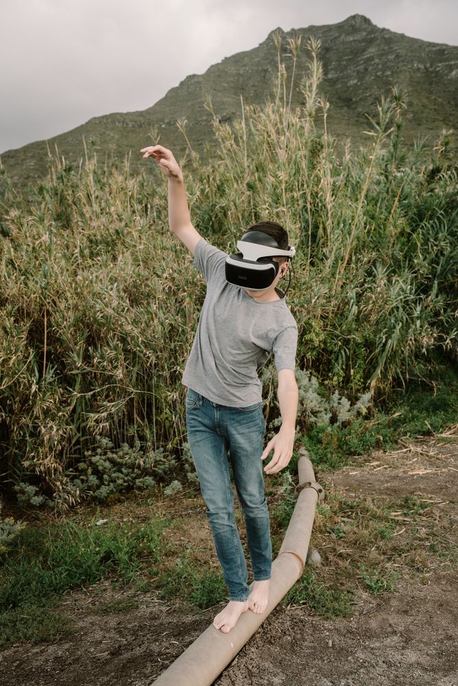 Young teenager with virtual reality glasses outdoors