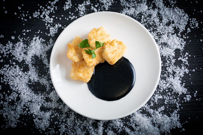 Hake breaded with squid cream in plate