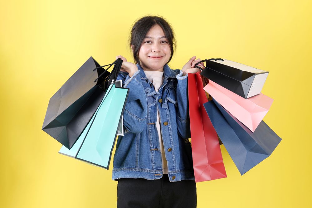 Young Asian Indonesian Woman Holding Colorful Paperbag and Smiling