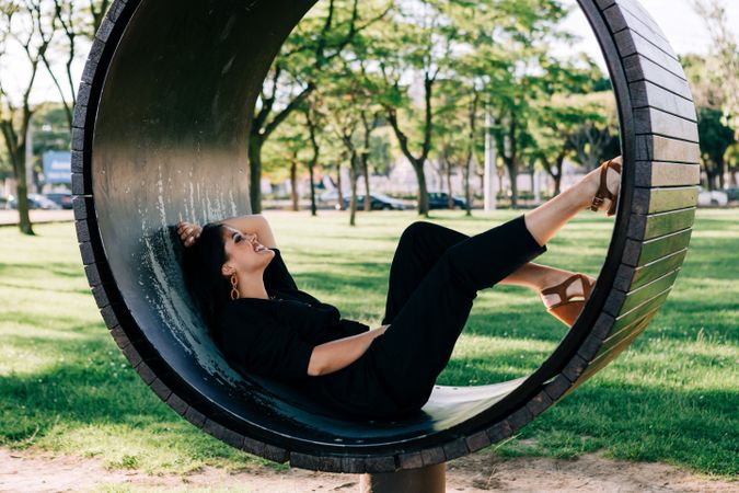 Young female relaxing on wooden round bench