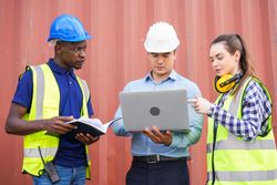 People in PPE gear on industrial site working together on strategic planning