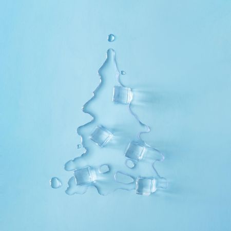 Ice cubes melting into the shape of a tree on blue background