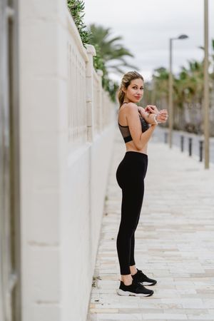 Woman in sports clothing stretching before exercise at seaside