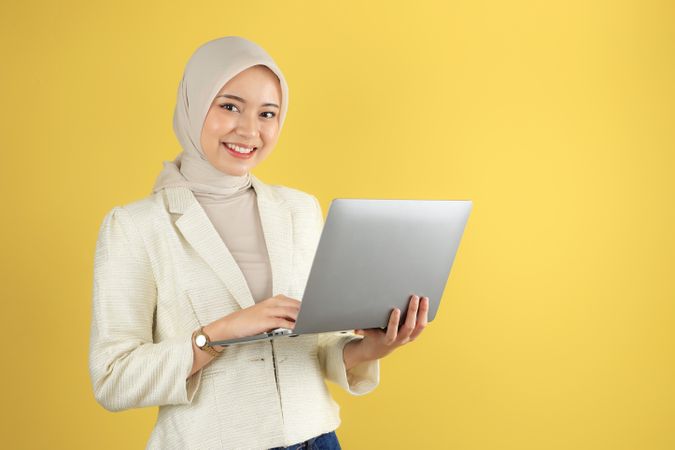 Smiling Young Beautiful Asian Muslim Woman with Laptop