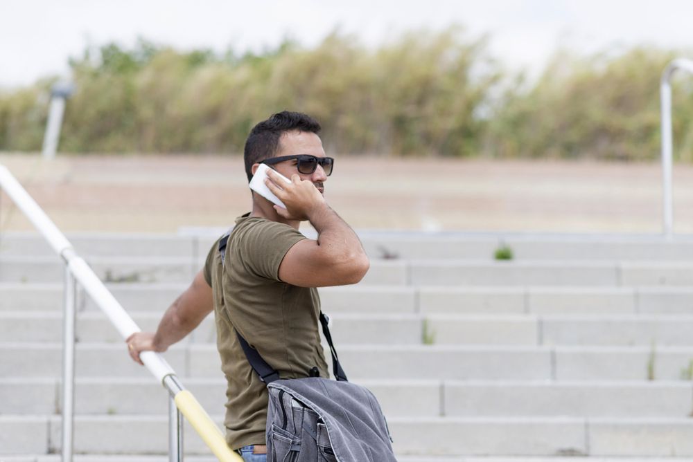 Male on outdoor stairs using cellphone