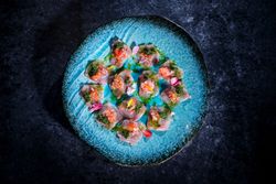 Plate with delicious fish dish on marble surface