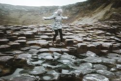 Female standing on cliff and contemplating