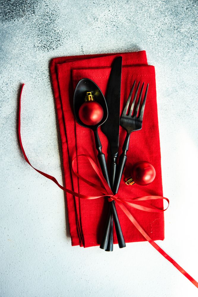 Christmas cutlery wrapped in red napkin and ornaments