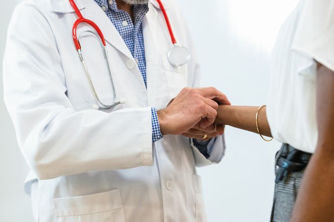 Doctor measuring pulse of patient
