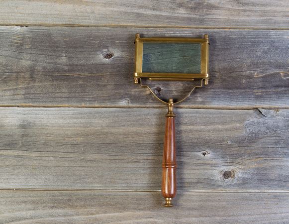 Magnifying glass on rustic wood