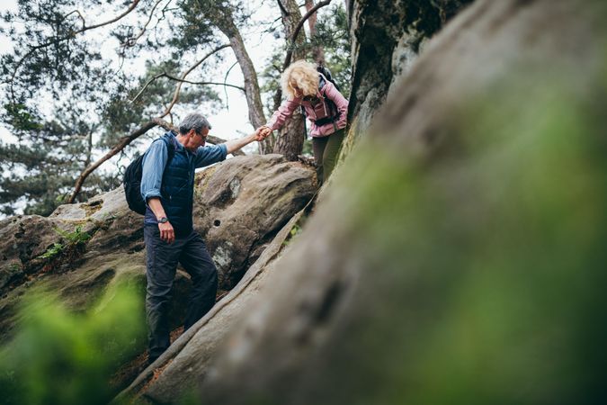 Man lends a helping hand to woman during a downhill trek