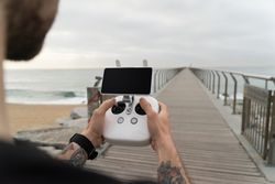 Man holding remote on boardwalk