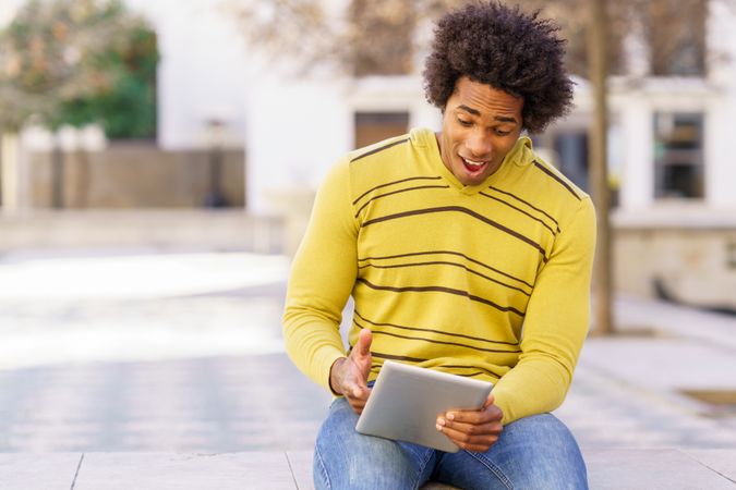 Man sitting outside using tablet for video call
