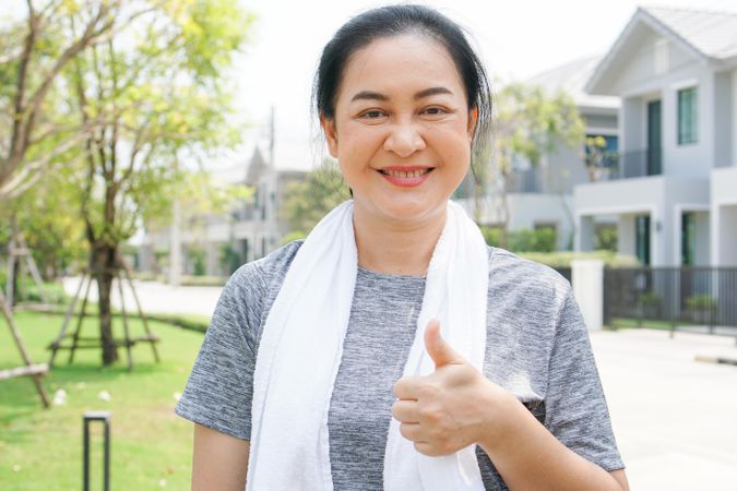 Portrait of happy woman giving thumbs up after workout