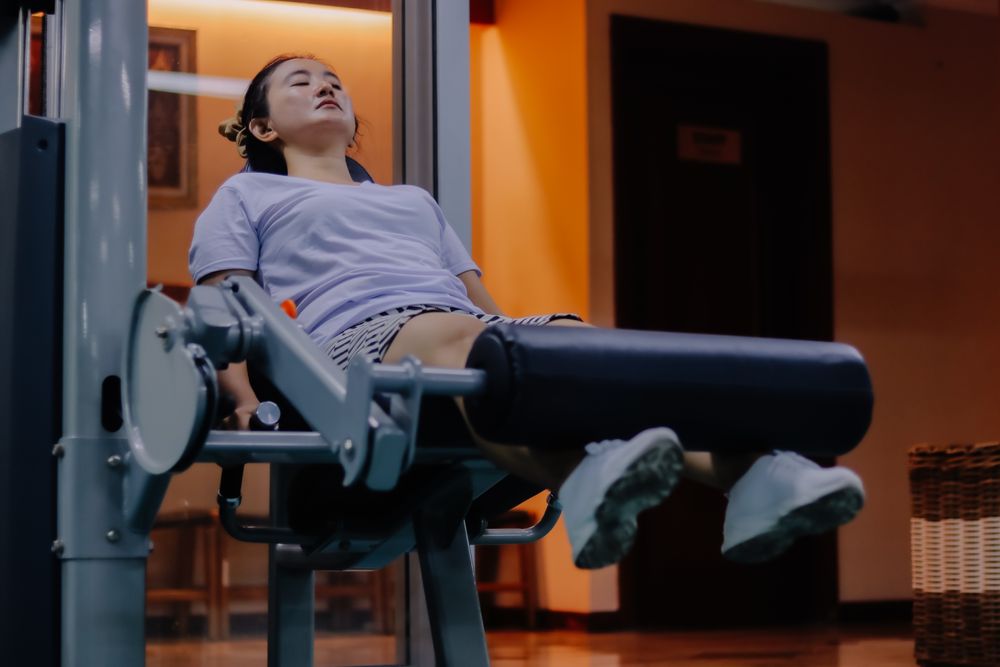 woman using leg extension machine