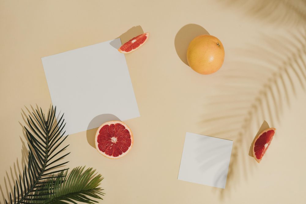 Minimal sunlit fruit and leaves composition with sand color background and sharp shadows