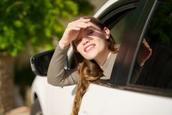 A Young Woman Happily Enjoying the Warm, Sunny Day While Looking Out From a Car Window