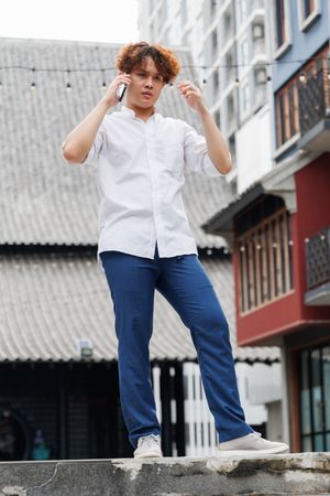 Asian man talking on the phone standing in city