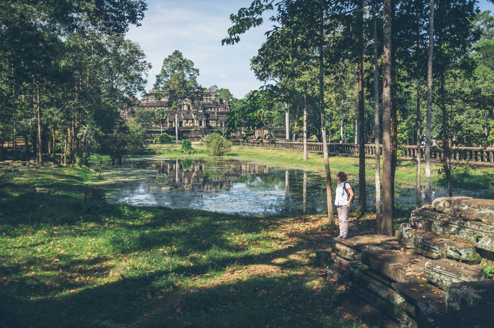 Female traveler in garden near temple