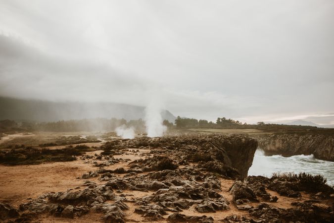 Crater between land and cloudy sky