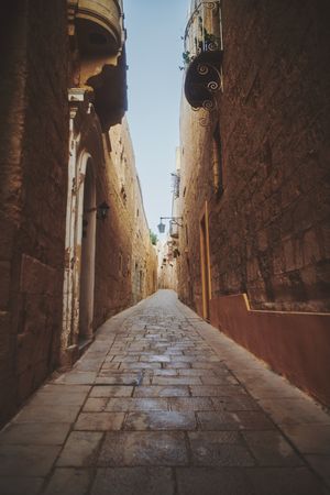 Quiet pedestrian walkway with small balconies in Mdina, Malta