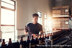 Young man working at small craft beer making factory and checking quality of alcoholic beverages 0V8vX4