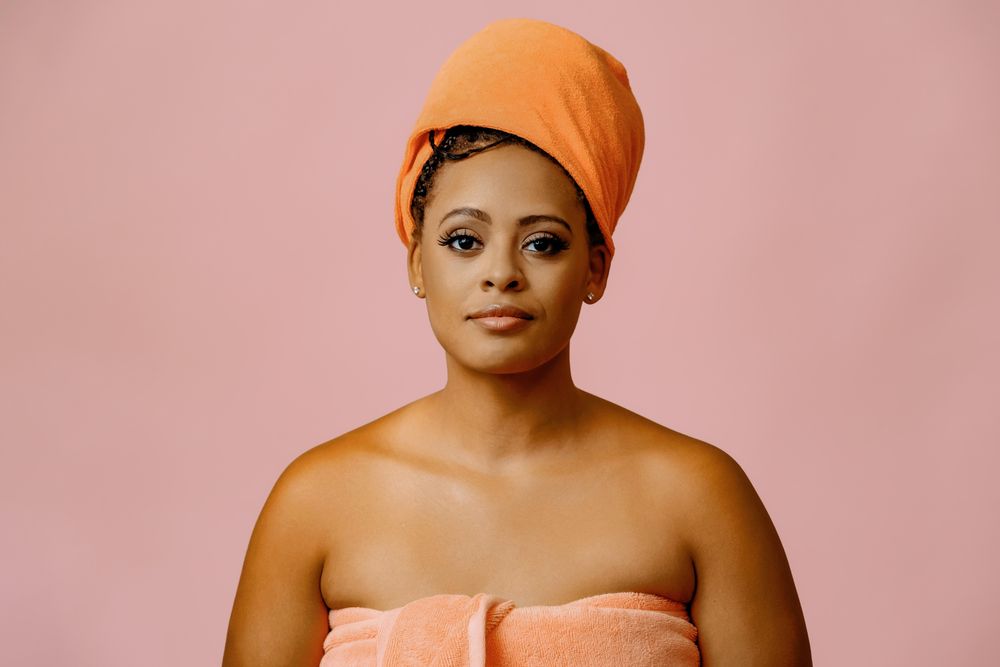 Serious female in towel with her hair wrapped after shower