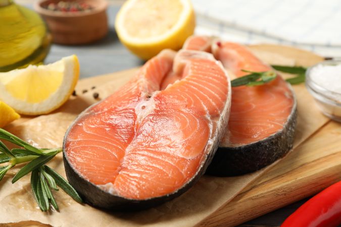 Composition with salmon meat and spices on wooden background, close up