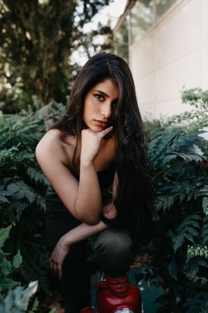 female standing near bushes