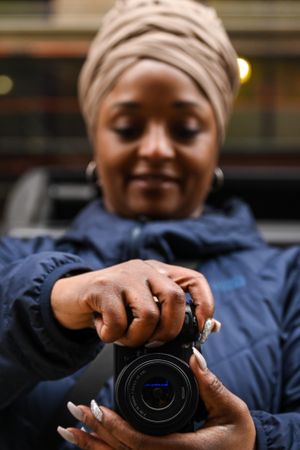 Woman wearing headwrap shooting with her camera