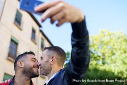 Two men taking a picture of them kissing bE8mN4