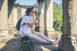 Female tourist reading guidebook in ruins