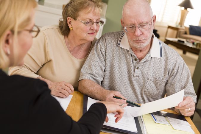 Older Adult Couple Going Over Papers in Their Home with Agent