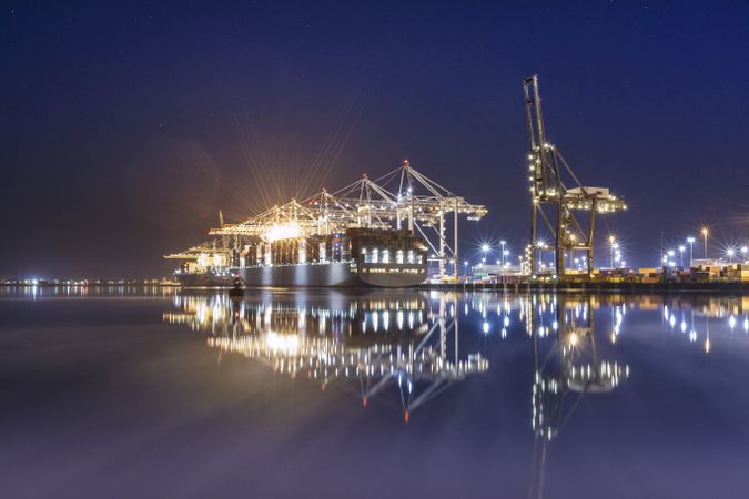 Freighters being loaded up with huge cranes at night