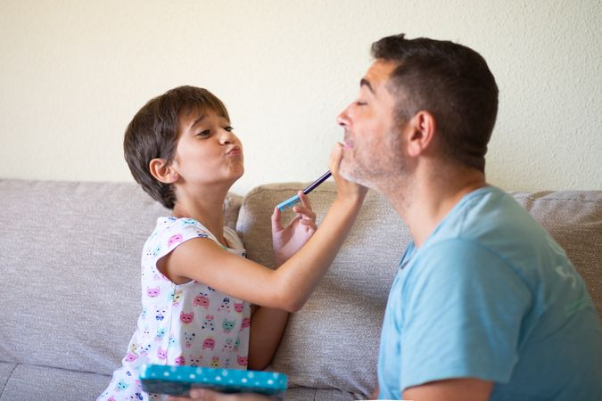 Girl practicing make up on her dad