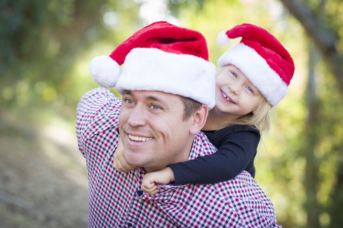 Father and Daughter Having Fun Wearing Santa Hats